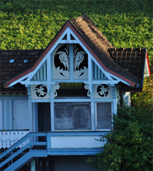 Ein Holzhaus vor einem grünen Hang